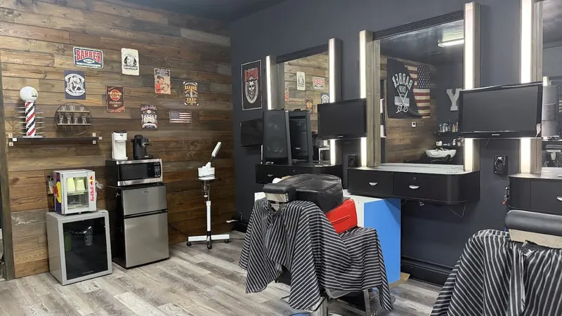 Two barber stations with lit mirrors and a wood wall